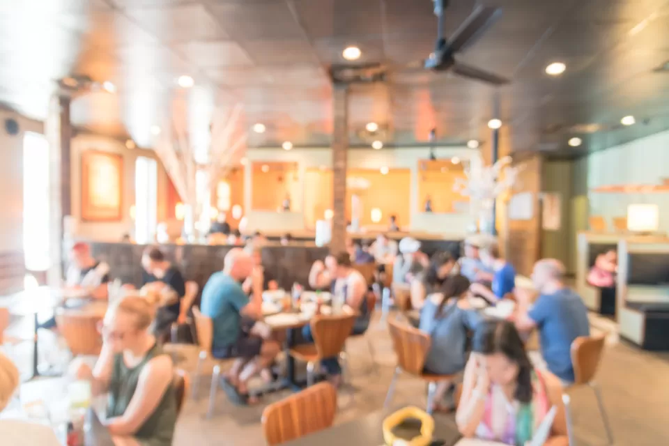 Blurred photo of crowded, brightly lit restaurant